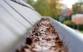 Rain falling into a clogged gutter