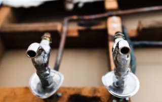 Two faucets on a wall with drywall torn out for repairs